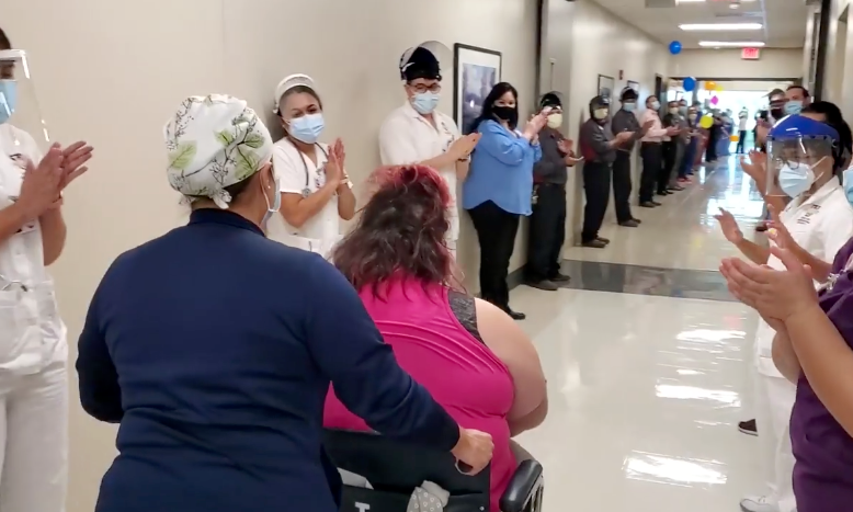 Hospital workers line the hallways to celebrate the discharge of recovered COVID-19 patient Nora D. Martinez.