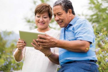 Older couple looking at an ipad in outdoor setting
