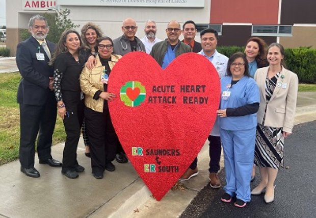 Employees of DHL standing with a heart-shaped sign that reads 'Advanced Certification in Acute Heart Attack Ready'